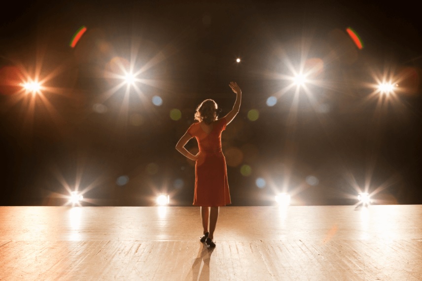 woman standing on stage with spotlights